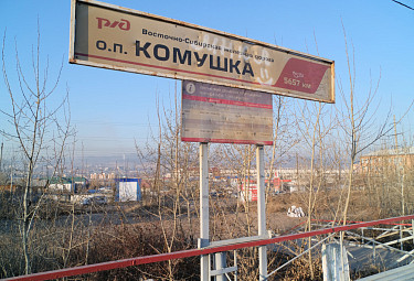 Станция "Комушка" на 5657 километре российских железных дорог - обшарпанный указатель, граффити, расписание электричек (2021 год). Бурятия